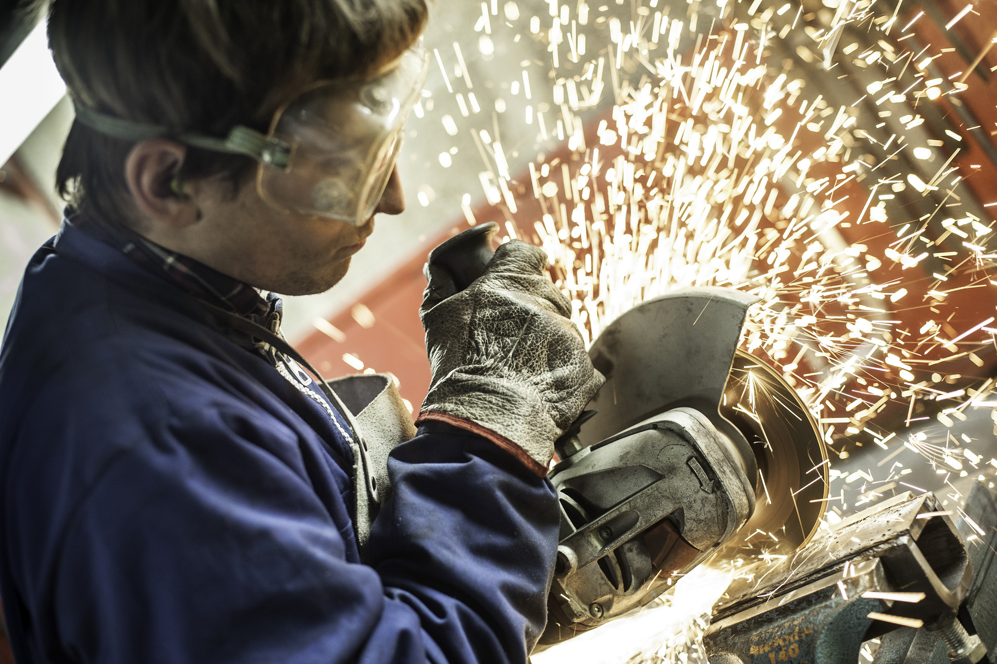 Artisan utilisant une meuleure pour découper